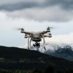 flying white quadcopter drone at daytime